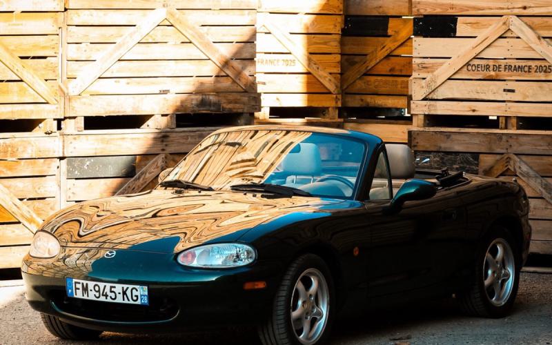Roadster devant des caisses en bois